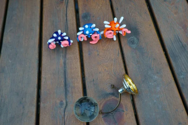 Virüsün figürleri ve yazıt tehlikesi. Yanında küçük cam bir küre var..