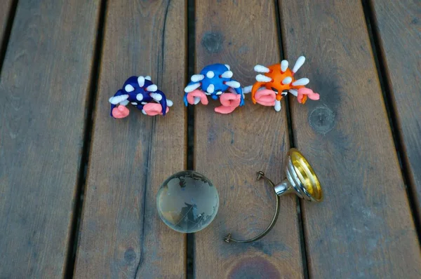 Virüsün figürleri ve yazıt tehlikesi. Yanında küçük cam bir küre var..