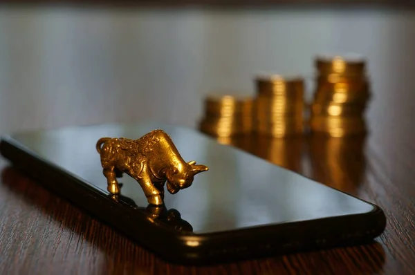 Metal bull and mobile phone on the table.