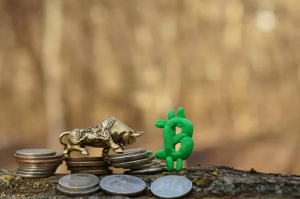 Metal bull and Bitcoin sign close-up.