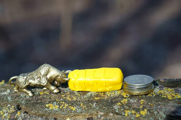 Metal bull with coins. Next to the inscription bull and bill.