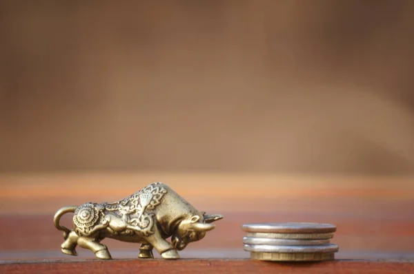 Metal bull with coins close-up. A financial symbol.