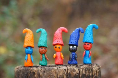 Renkli arkaplanda çok renkli cücelerin figürleri.