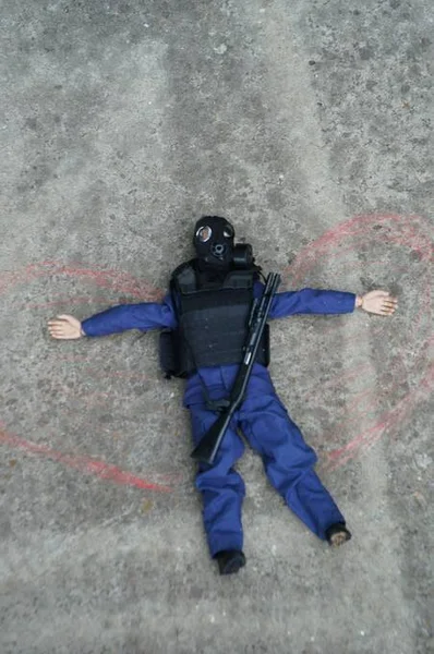 Toy soldier with a gas mask on the concrete surface. On the sides of it are painted wings. Image of an angel. Apocalypse.