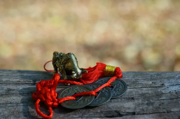 Metal bull figurine with Chinese coins close-up.