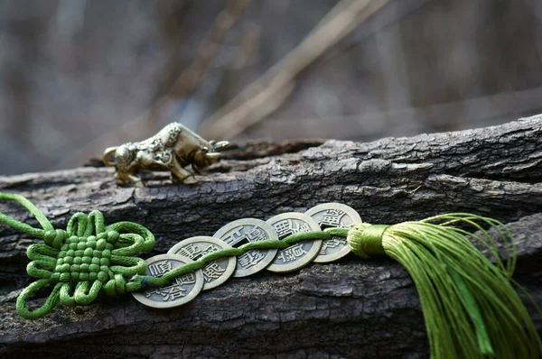 Metal bull and Chinese Feng Shui coin. The coin has the inscription in Chinese prosperity, wealth, jewel and luck.