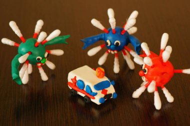 Oyuncak araba ambulansı ve masadaki virüsün şekli..
