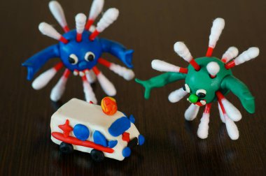 Oyuncak araba ambulansı ve masadaki virüsün şekli..