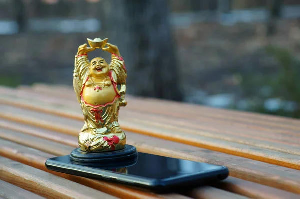 Eine Buddha Statue Und Ein Handy — Stockfoto