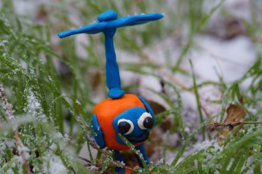 Yeşil çimenlerin arka planında oyuncak helikopter. İlk kar.