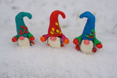 Beyaz karlı arka planda üç cüce figürü.