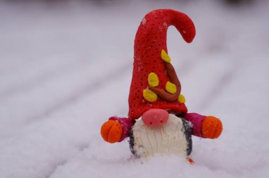 Kar zemininde plastikten yapılmış bir cüce figürü..