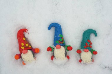 Beyaz karlı arka planda üç cüce figürü.