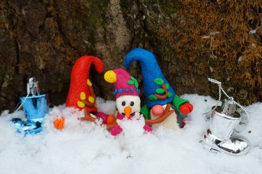 Kış ormanlarında kardan adam ve cüce figürler.