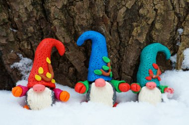 Kar ve ahşap arka planda cüce figürleri.