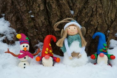 Noel figürleri bir sırada duruyor. Bir kardan adam, bir melek ve birkaç cüce..