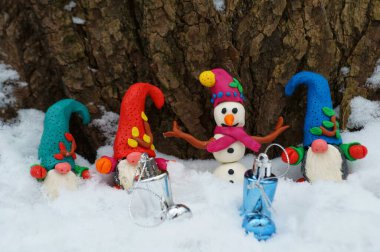 Kış ormanlarında kardan adam ve cüce figürler.