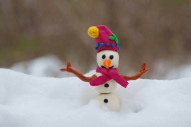 Kış ormanında bir kardan adamın heykeli..