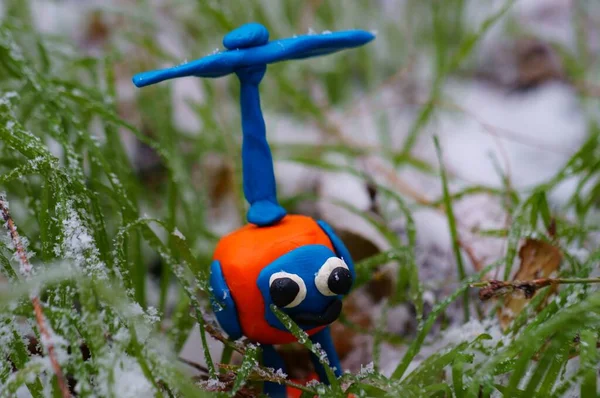 Yeşil çimenlerin arka planında oyuncak helikopter. İlk kar.