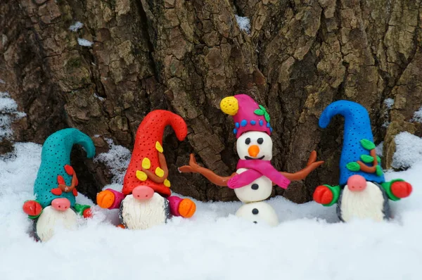 Kış ormanlarında kardan adam ve cüce figürler.