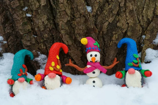 Kış ormanlarında kardan adam ve cüce figürler.