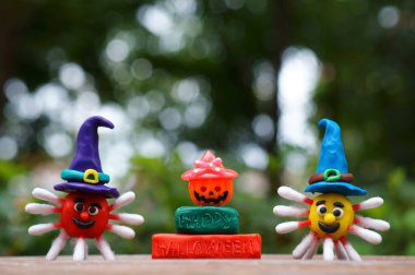 Şenlik şapkasındaki plastikten bir virüs figürü. Yazıtın yanında Mutlu Cadılar Bayramı ve bir balkabağı. Cadılar Bayramı konsepti. Yakın plan..