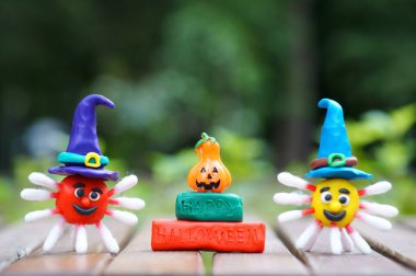 Şenlik şapkasındaki plastikten bir virüs figürü. Yazıtın yanında Mutlu Cadılar Bayramı ve bir balkabağı. Cadılar Bayramı konsepti. Yakın plan..