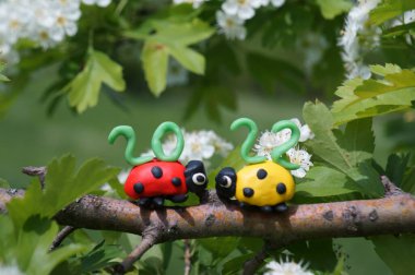 Plastikten yapılmış iki uğur böceği figürü. En üstte takvim tarihi 2022..