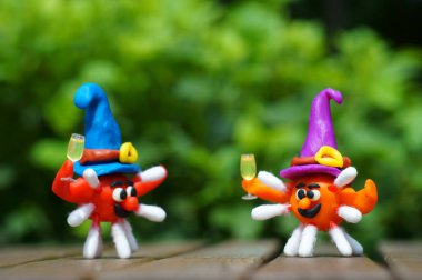 Şenlik şapkasında bir kadeh şampanya olan bir virüs figürü. Cadılar Bayramı konsepti.