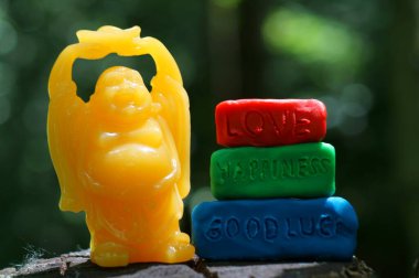 Renkli arka planda Buda figürü. Yazıtın yanında aşk, mutluluk, iyi şanslar..