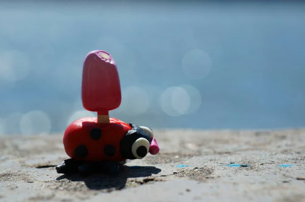 Uma Joaninha Brinquedo Feita Plasticina Com Sorvete Fundo Mar — Fotografia de Stock