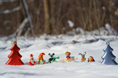 Kış ormanındaki peri masalı karakterlerinin figürleri. Yetenekli bir melek, cüce, havuçlu bir tavşan, Noel Baba, panda, eşarplı bir penguen. Yakında oyuncak Noel ağaçları var..