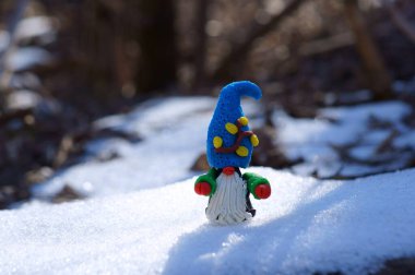 Karlı bir ormanda plastikten yapılmış bir cüce heykeli..