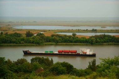 Nehirde tankı olan bir mavna yüzüyor. Doğal manzara..