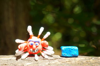 Plastikten yapılmış bir koronavirüsün yakın plan figürü. 2022 sayısının yanında..