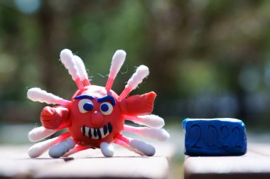 Plastikten yapılmış bir koronavirüsün yakın plan figürü. 2022 sayısının yanında..