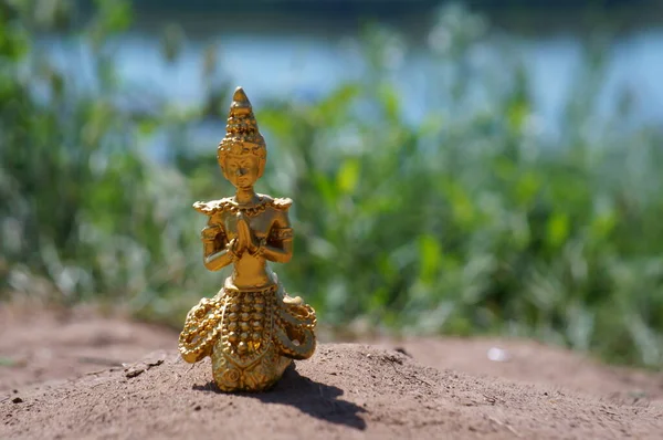 A figure of a meditating Buddha in nature. A spiritual symbol.