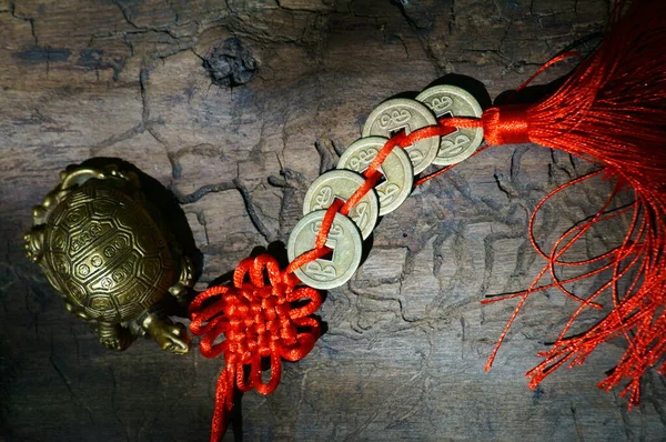 一只金属龟和一堆中国硬币在黑暗明亮的背景下 图库照片