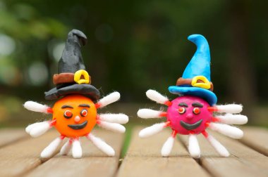 Virüsün iki figürü şenlikli bir şapkada plastik maddeden yapılmış. Cadılar Bayramı teması. Cadılar Bayramı için bir çizim.