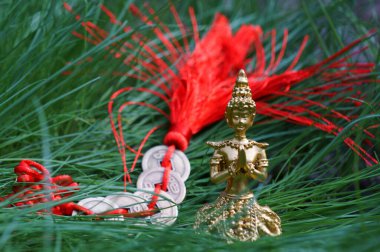 Yeşil çimlerde meditasyon yapan bir Buda heykeli..