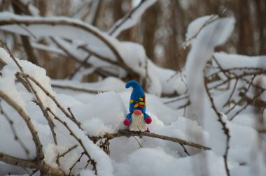 Karlı bir ormanda bir cüce figürü..