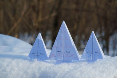 Karlı bir ormanda kağıt oyuncaklar Noel ağaçları.