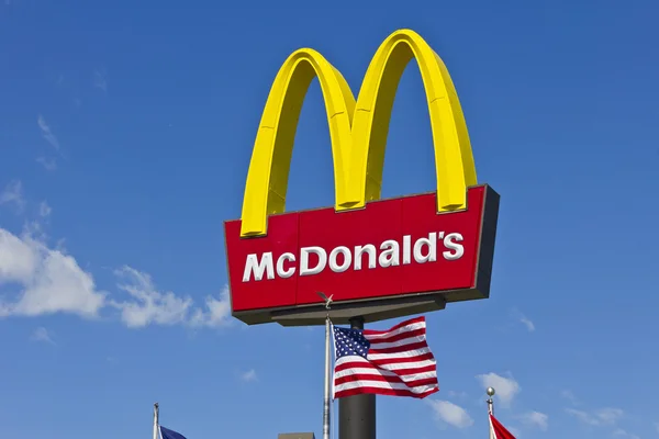 Indianapolis - Circa March 2016: McDonald 's Restaurant Sign with American Flag. McDonald 's - это сеть ресторанов Гамбургера III — стоковое фото