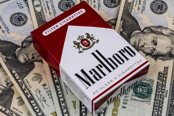 Indianapolis - ca augusti 2016: Paket Marlboro cigaretter och tjugo Dollar räkningar som representerar de höga kostnaderna för rökning. Marlboro är en produkt av det Altria grupp Iii — Stockfoto