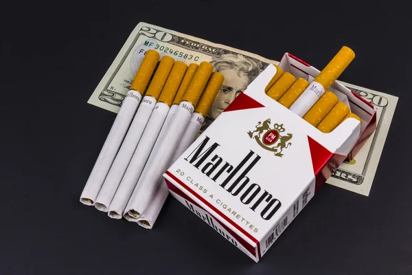 Indianapolis - Circa sierpień 2016: Marlboro papierosy i dwadzieścia dolarowych reprezentujących wysokie koszty palenia. Marlboro jest produktem firmy Altria Group I — Zdjęcie stockowe