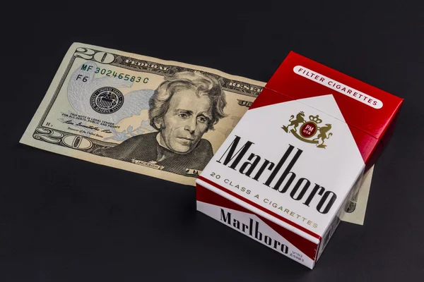 Індіанаполіс - Circa серпня 2016: Сигарети Marlboro і двадцять доларових купюр, що представляють високі витрати на куріння. Marlboro є продуктом Altria Група Viii — стокове фото