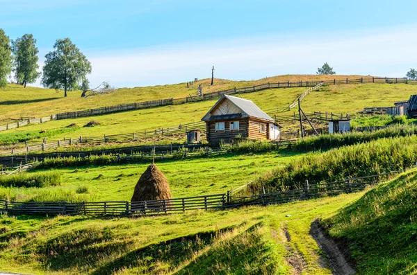 Summer rural landscape with house and haystacks — Stock Photo, Image