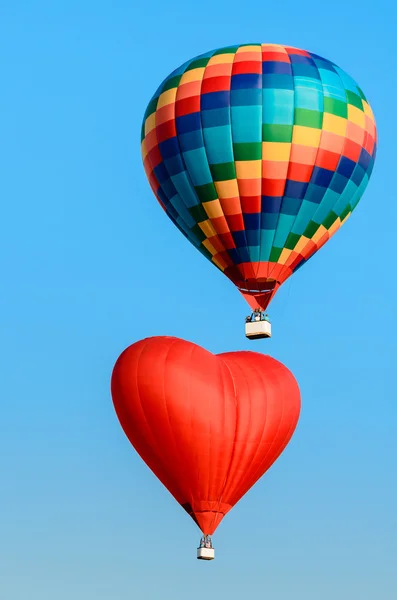 Dvě barevné horkovzdušný balón letí na modré obloze — Stock fotografie
