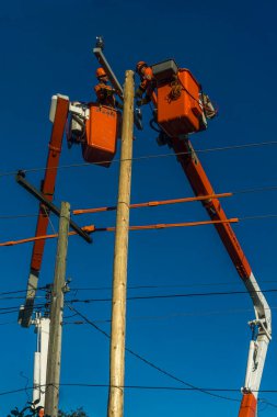 Toronto, Kanada, Ekim 2017 - Turnalar üzerinde çalışan iki elektrik hattı çalışanı ve bakım ve onarım için kablo