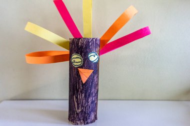 Handmade craft by child representing a figure with eyes, nose and hair clipart